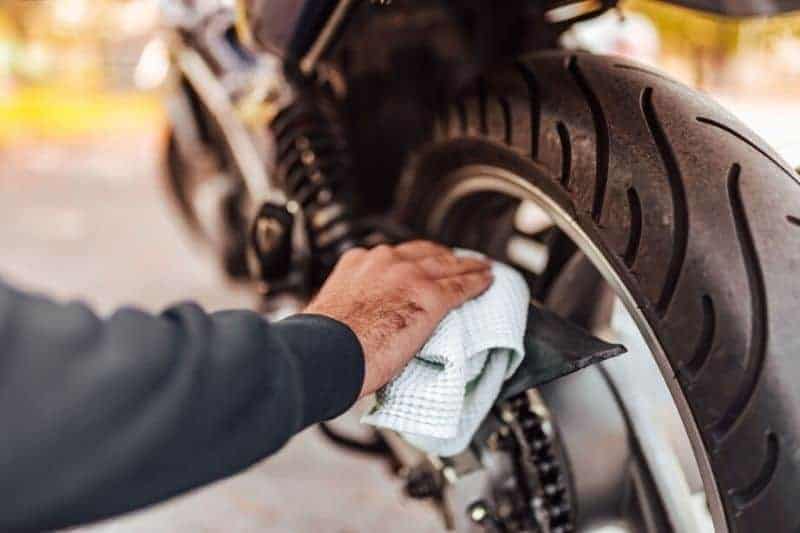 A man cleaning his motorcycle.