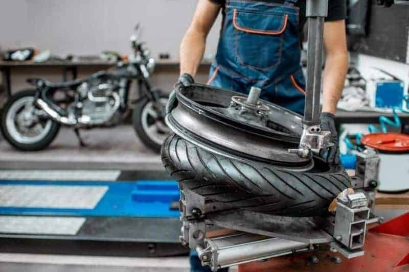 A mechanic changing a motorcycle tire