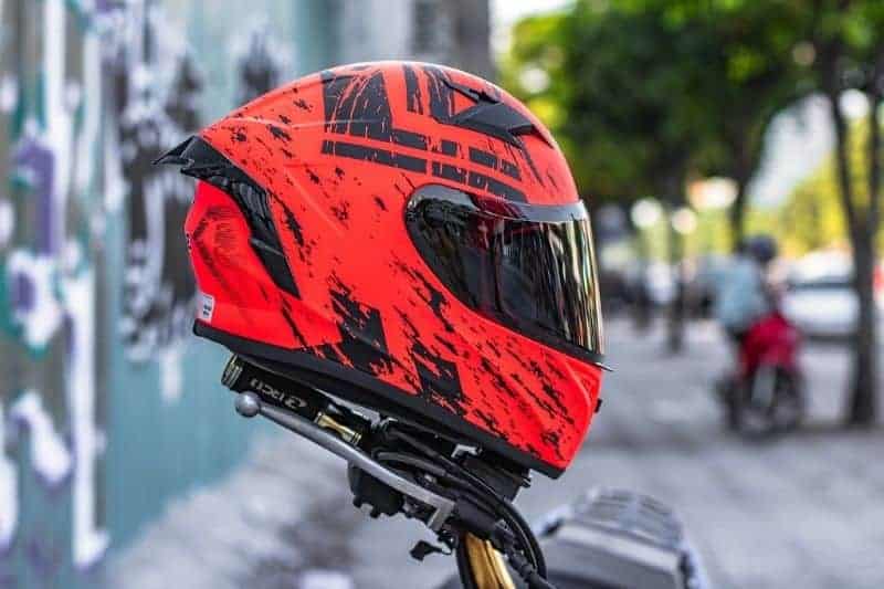 A close-up of a red full face motorcycle helmet