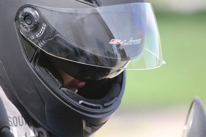 A close up of a motorcyclist wearing a helmet.